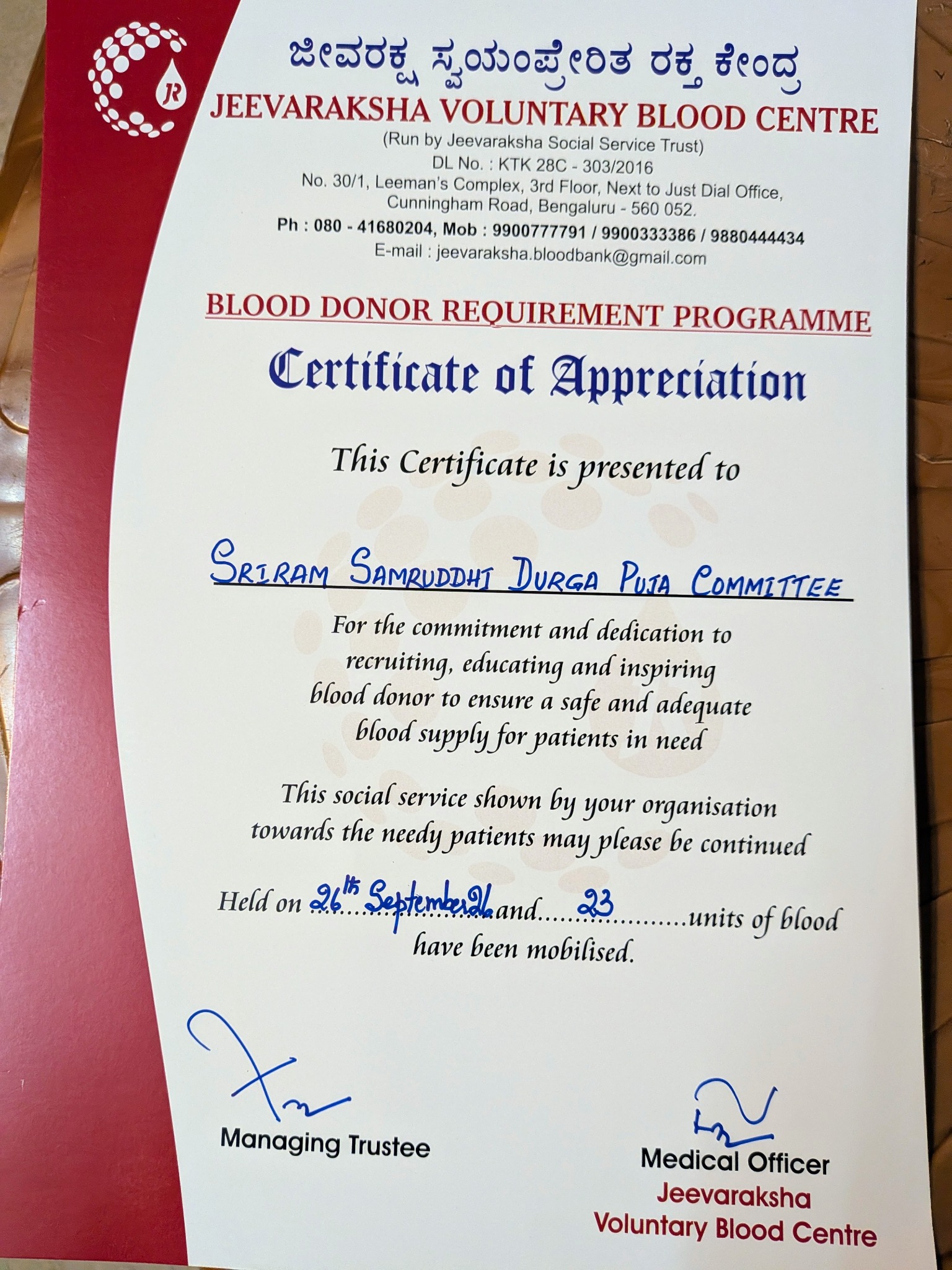 Certificate of Appreciation from Jeevaraksha Voluntary Blood Centre to Shriram Samruddhi Durga Puja Committee, recording 23 units of blood donated on 26 September 2026.
